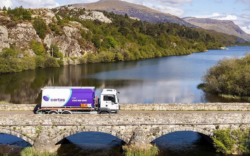 Certas Energy truck driving over stone bridge.