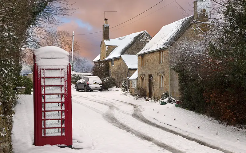 A road covered in snow with a red letterbox.