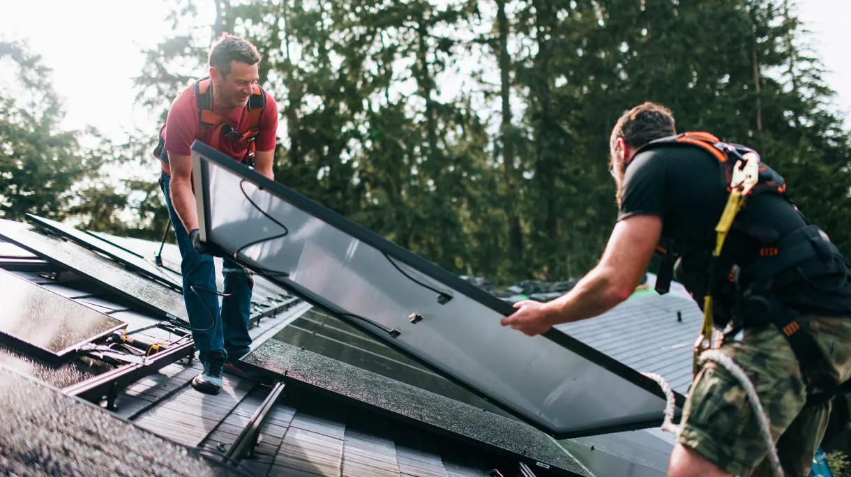 Solar installers mounting panels on home rooftop