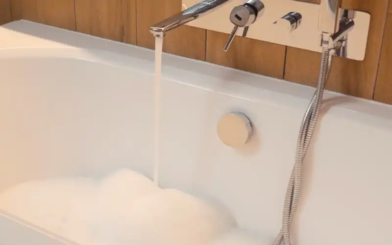 Water coming out of a tap filling up a sink.