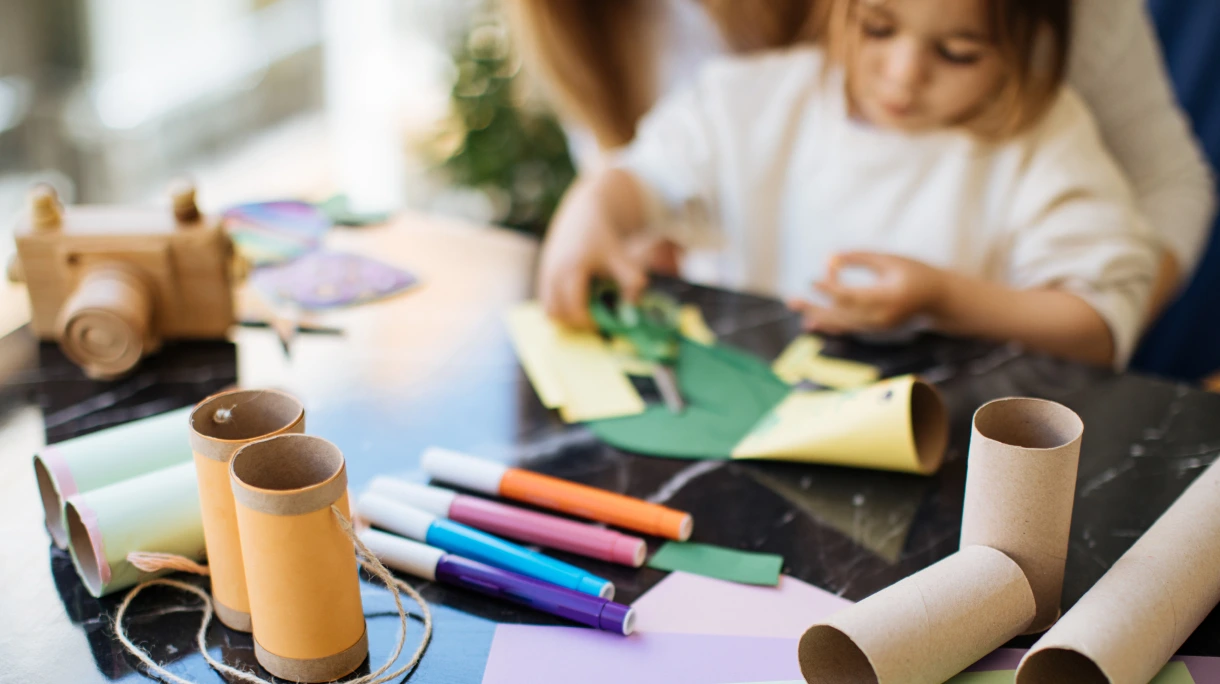 Child crafting binoculars from toilet paper rolls