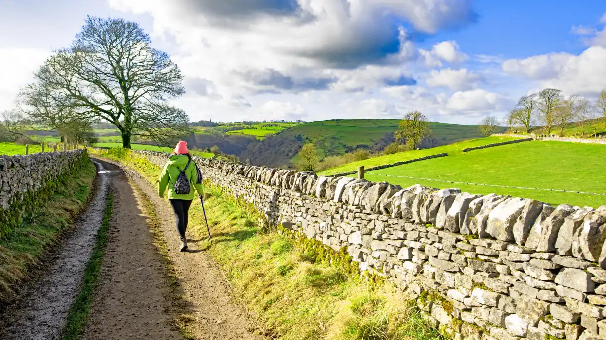 Woman hiking through UK countryside on off-grid adventure